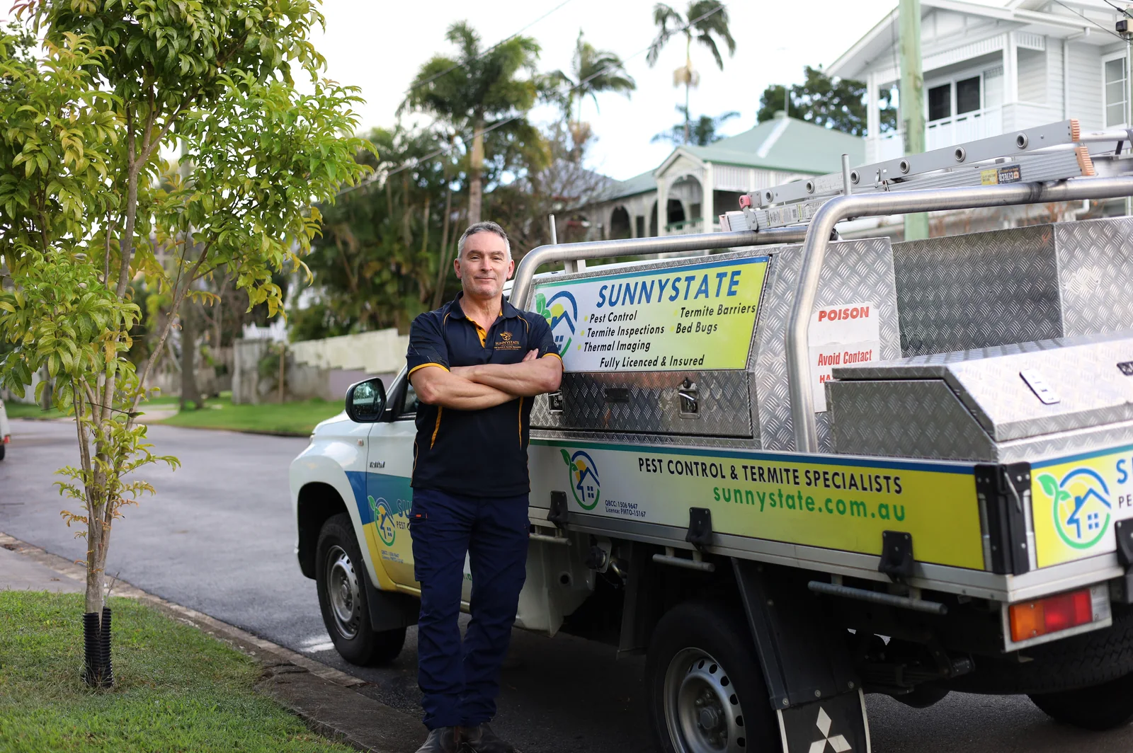 Joel, Sunnystate Pest Control technician, with branded ute at a Brisbane property